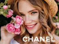 Esta chica sonriente y con sombrero de paja, se saca una foto junto a un rosal de rosas rosas. Huele estupendamente porque se ha echado coco madmoiselle, de Chanel.
