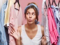 Esta chica está mirando la ropa de su armario, está pensando cómo quitar el olor a perfume que algunas de sus prendas todavía conservan.