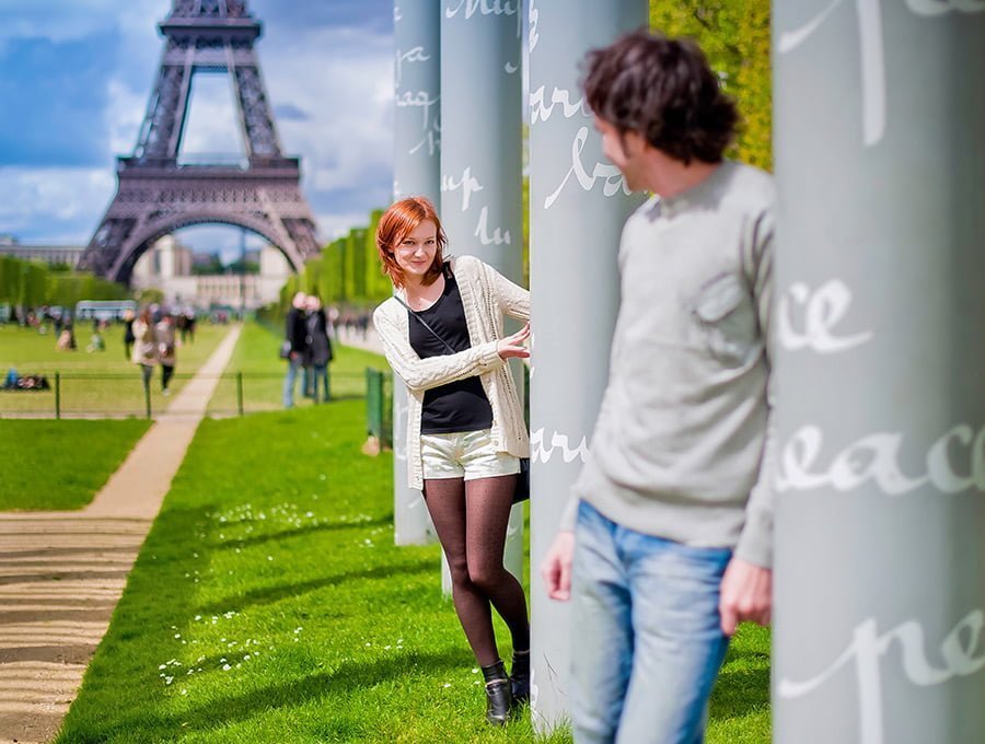 Esta pareja ha viajado a Paris a ver monumentos. También han comprado perfume dyptique parisino. Ahora están en frente de la torre Eiffel pasando el día con felicidad.