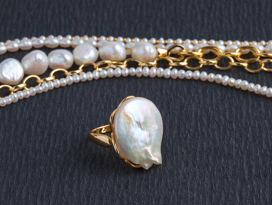 Un anillo de oro con una perla cultivada. También hay un collar de oro con perlas incrustadas. Son my caros y las perlas son auténticas.