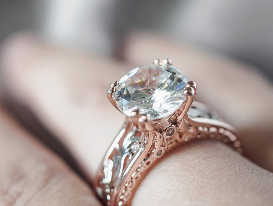 Esta mujer lleva puesto un anillo de promesa de oro rosa y un diamante de gran tamaño.