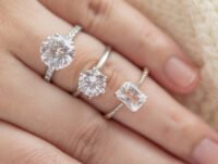 Esta mujer lleva tres anillos apilados de diamantes y oro blanco en uno de sus dedos.