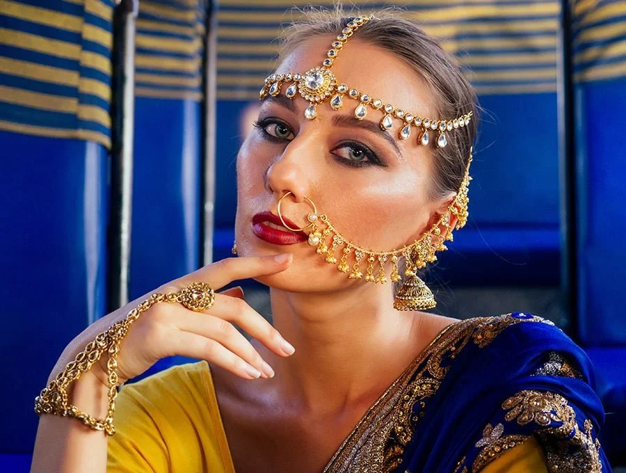 Esta mujer lleva ropa india. Además de varias joyas de oro de 14k que adornan su rostro y manos.