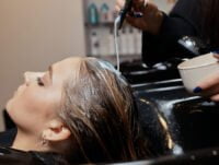 Esta estilista está colocando una crfema de nioxin hidratante en el cabella de su clienta. Lo dejará actuar algunos minutos y después aclarará con abundante agua.