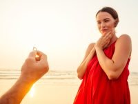 Este hombre regala un anillo de promesa a su pareja en la playa.