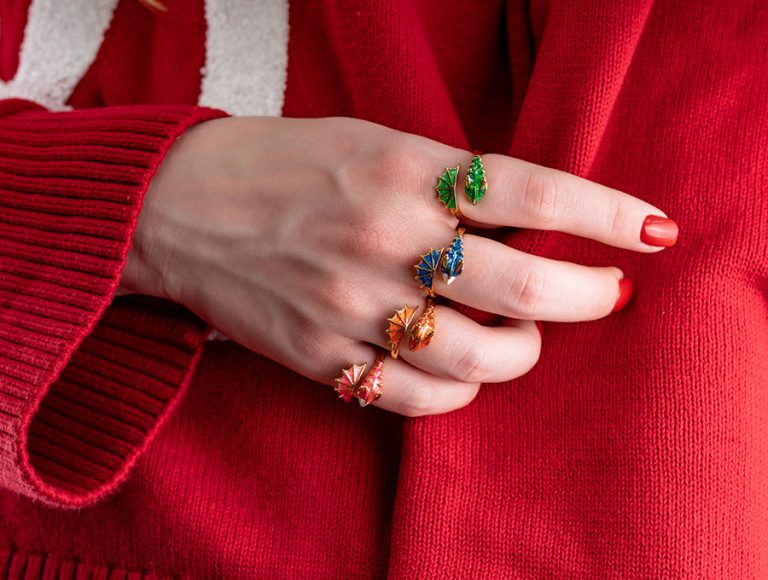 Mujer lleva varios anillos de la marca paparazzi en sus dedos.