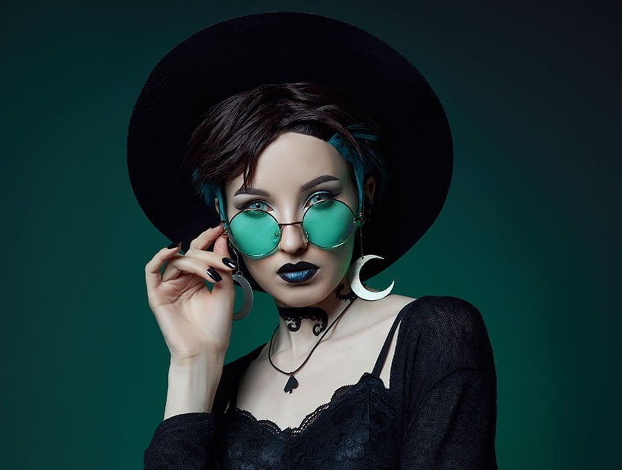 Mujer con ropa gótica de estilo vintage, tiene los labios pintados de tono oscuro.